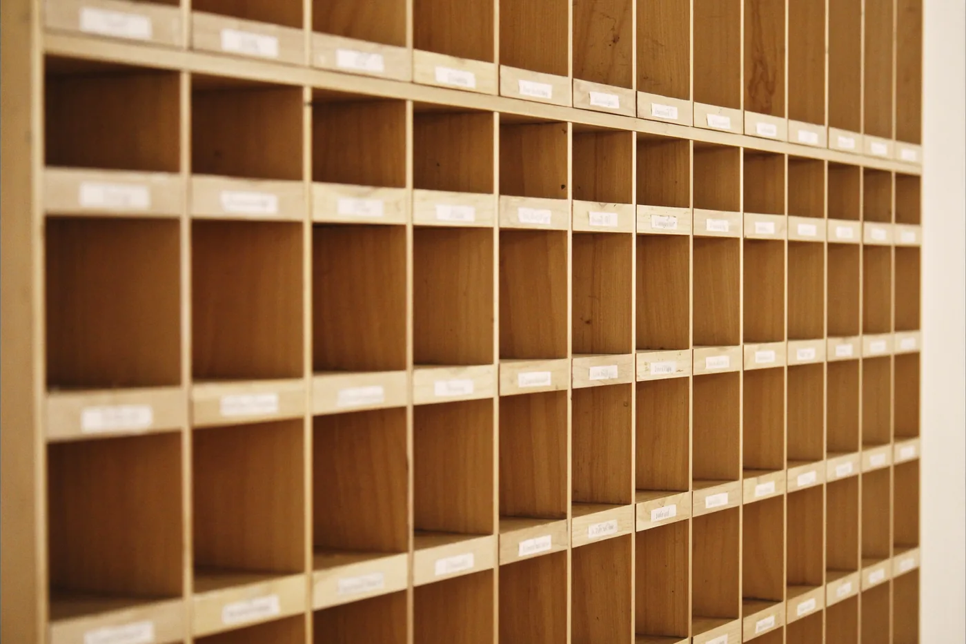 Rows of wooden document-sorting compartments in warm office light.
